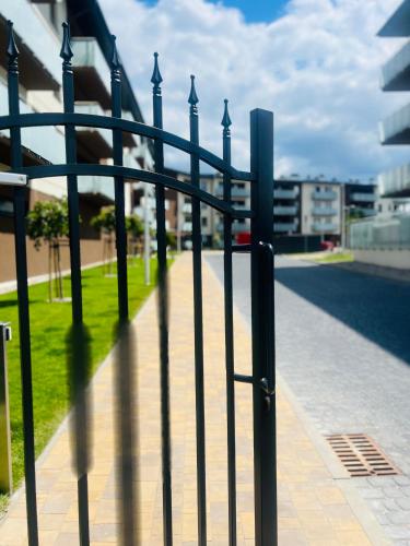 a fence on a sidewalk next to a street at Apartament Poznańska 1 in Suwałki