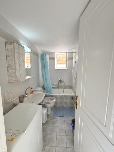 a bathroom with a tub and a toilet and a sink at Prince of Aegean - Two Balconies in Ermoupoli