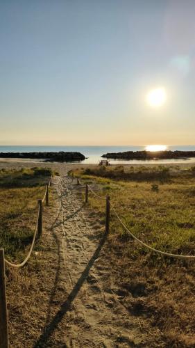 a fence on a beach with the sunset in the background at Sake' Beach in Senigallia