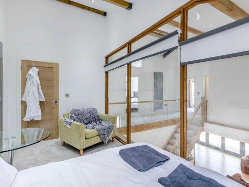 a bedroom with a bed and a chair at Howell Hall Barn in Howell