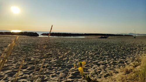 a sandy beach with a bridge in the background at Sake' Beach in Senigallia