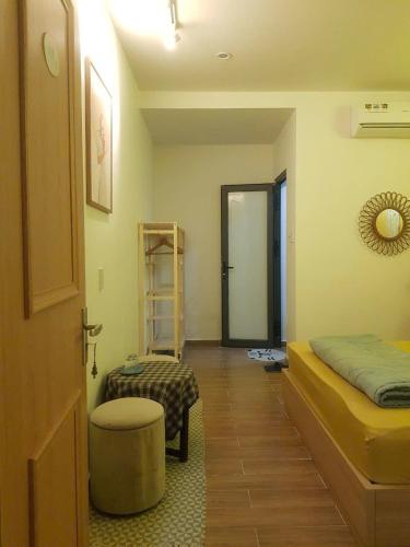 a room with a bed and a stool and a ladder at Na Homestay in Hue