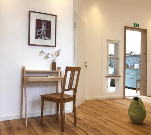 a room with a wooden desk and a chair at klein & fein Gästehaus in Schwelm