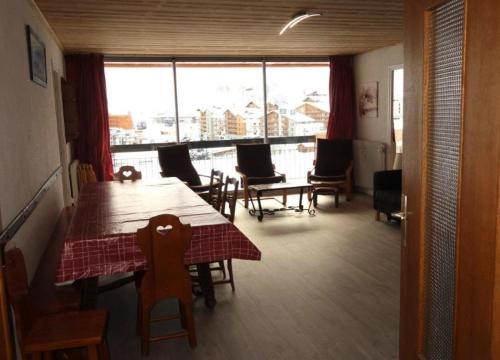 une salle à manger avec une table et des chaises et une grande fenêtre dans l'établissement Résidence Horizon - Appartement 3 Pièces QUARTIER BERGERS-PIEDS DES PISTES-DEPART ESF MAE-2121, à Huez