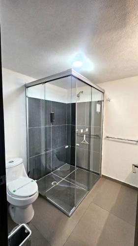 a bathroom with a glass shower with a toilet at S10 DOBLE CAMA MATRIMONIAL Premium Suite Frente al TEC CEM con Cocineta WiFi Balcón Parking Terraza in Mexico City