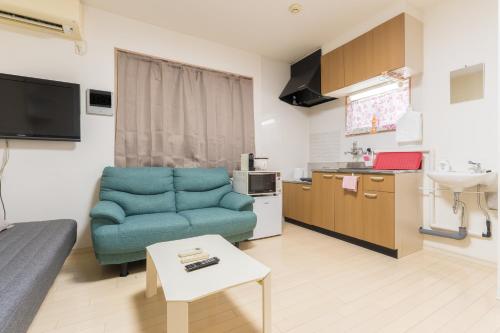 a living room with a blue couch and a kitchen at Direct Access to Umeda Private Stay for 3 Guests in Osaka