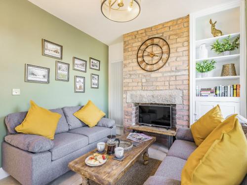 a living room with a couch and a fireplace at Spa Cottage in Bakewell
