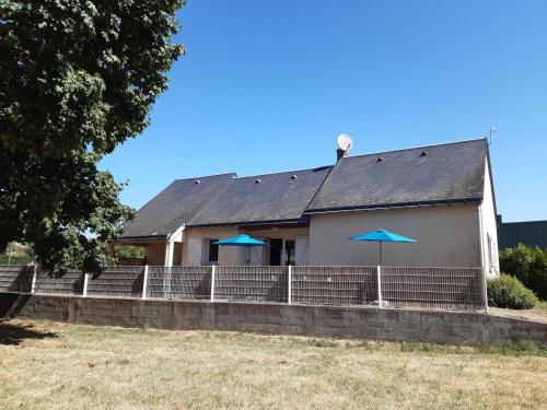 a white house with blue umbrellas in front of it at Camping Onlycamp les Bords de Vienne in L'Ile-Bouchard