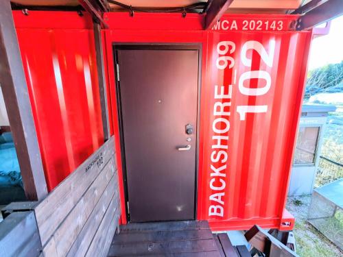 a red entrance to a building with a red door at Backshore 99 in Kujukuri