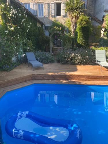 a blue swimming pool in front of a house at La Maison 64 Chambre D'Hôtes in Barbaste