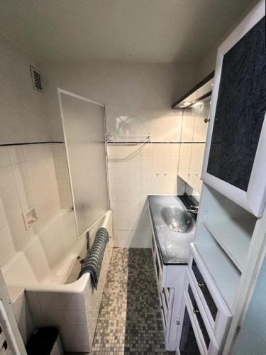 La salle de bains est pourvue d'un lavabo, d'une baignoire et d'un porte-parole. dans l'établissement Résidence Paradis B - APPARTEMENT 2 PIECES -ALPE D'HUEZ QUARTIER DU VIEL ALPE MAE-9603, à Huez