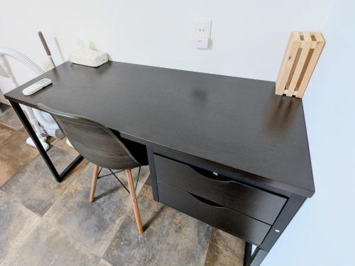 a black desk with a chair in a room at Backshore 99 in Kujukuri