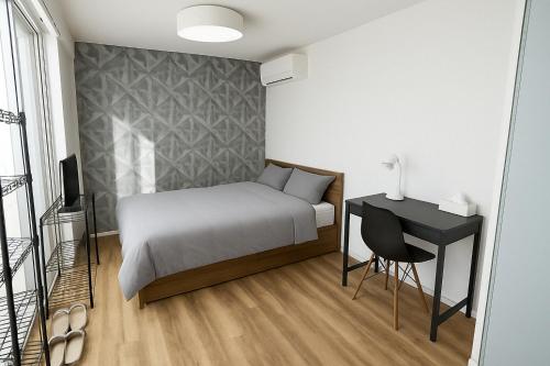 a bedroom with a bed and a table and a chair at Backshore 99 in Kujukuri