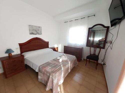 a bedroom with a bed and a mirror and a chair at Arcadia Centro de Andalucía in Encinas Reales