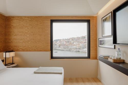 a bedroom with a window with a view of a harbor at Porto River Soul Hotel in Vila Nova de Gaia