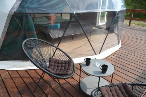 a deck with two chairs and a table and a tent at Глемпінг Zatuшшя in Berezovka