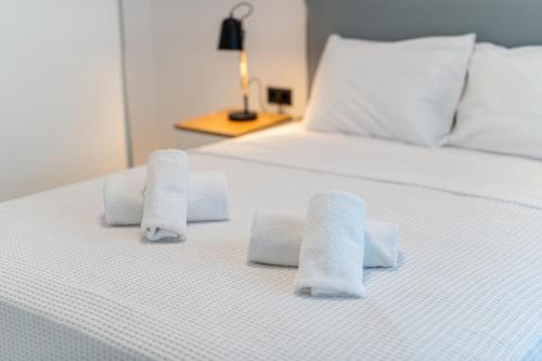 a white bed with three towels on it at Emerald Island Residential Complex in Skala Rachoniou