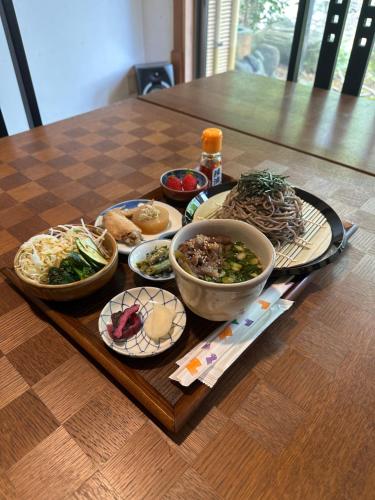 a table with bowls of food on a wooden table at Onsen Yado Mizuguchi in Izu