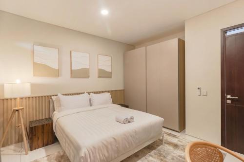 a bedroom with a large bed with white sheets at Arumnala with butler and Breakfast at KBP in Gantungan