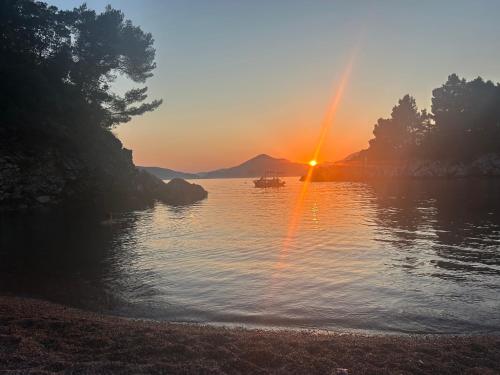 a sunset over a lake with a boat in the water at Studio Sea View Steps to Przno beach w Parking Villa Olive in Pržno