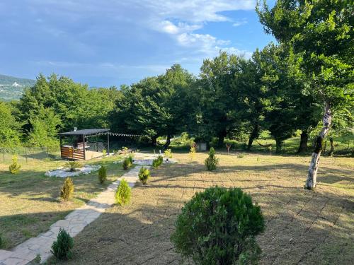 a garden with a gazebo and trees at Wooden Villa Sormoni in Tskaltubo
