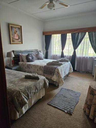 a bedroom with two beds and a window at Buitehof Gasteplaas in Stewartby