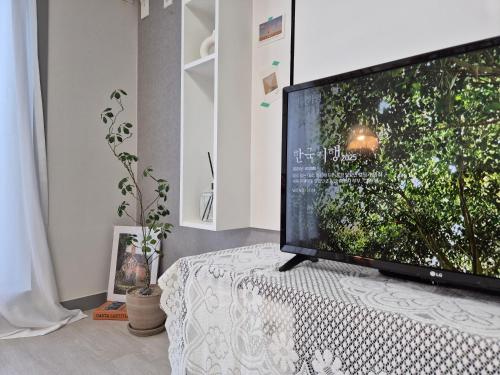 a large television sitting on a table in a room at Eumm stay in Cheongju