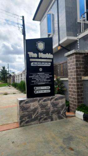 a large sign in front of a house at The Marble Hotel and Apartments in Uyo