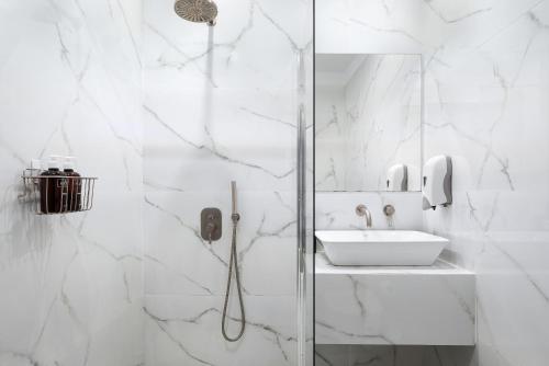 um banheiro branco com chuveiro e pia em Standard Suite by Acropolis Cozy Suites em Atenas