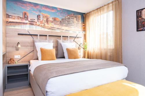 a bedroom with a large bed with a painting on the wall at HOTEL Am Spichernplatz in Düsseldorf
