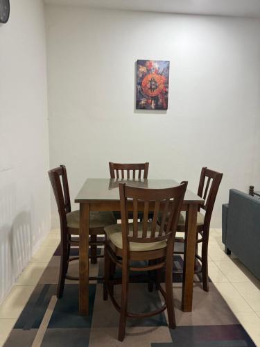 a dining room table and chairs with a picture on the wall at Cryptohouse Pantai Kelulut in Marang