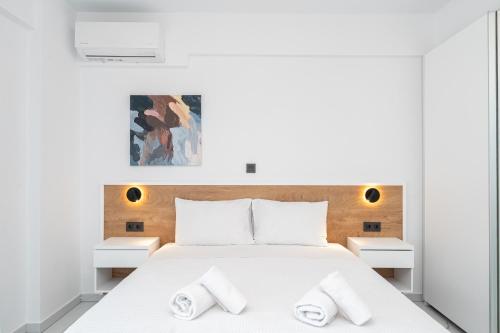 a bedroom with a white bed with two white night stands at Emerald Island Residential Complex in Skala Rachoniou