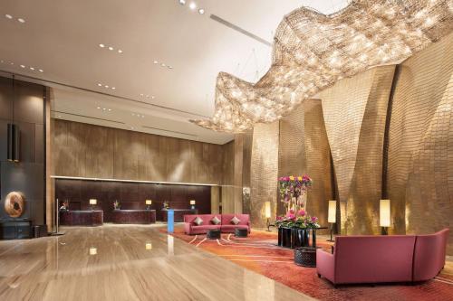 a lobby with chairs and a large chandelier at Hilton Guangzhou Tianhe - Free Shuttle Bus and Registration Counter Available during Canton Fair Period in Guangzhou