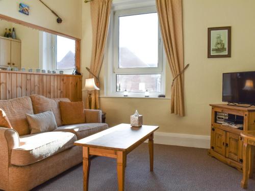 a living room with a couch and a tv at Seasider in Whitby