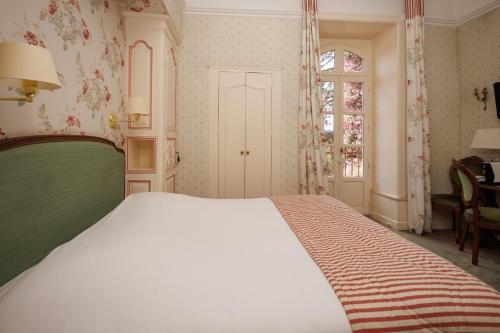 a bedroom with a large bed and a window at Château de Castel Novel Boutique Hôtel in Varetz