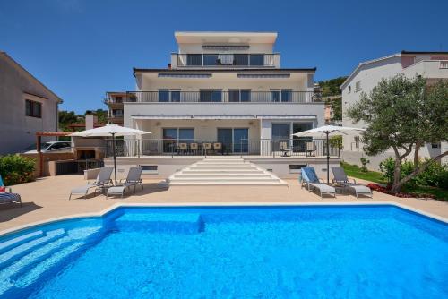 a large swimming pool in front of a house at Villa Mila Trogir in Trogir