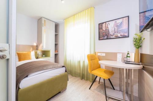 a bedroom with a bed and a table and a chair at HOTEL Am Spichernplatz in Düsseldorf