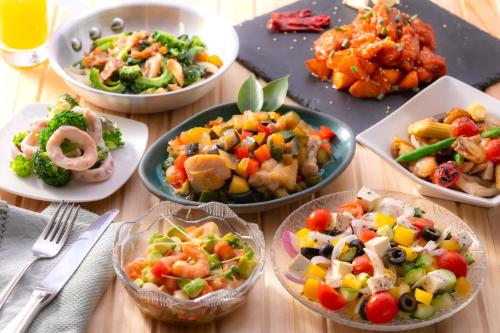 広島市にあるホテルインターゲート広島のさまざまな種類の食べ物が入ったボウルが置かれたテーブル