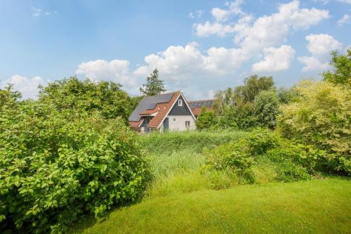 a house in the middle of a field with trees at Irina - Peaceful Holiday Home near Lauwersmeer National Park in Anjum