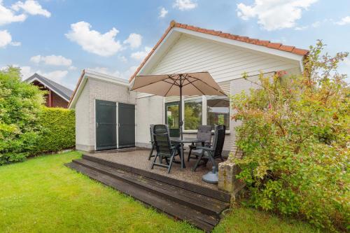 a patio with a table and an umbrella at Irina - Peaceful Holiday Home near Lauwersmeer National Park in Anjum