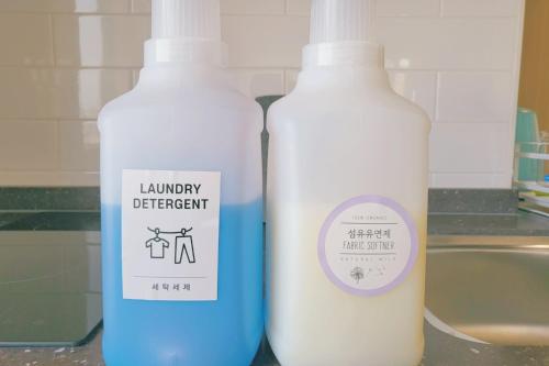 two bottles of laundry detergent sitting next to a sink at Jeju The Terrace View in Jeju