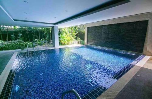 a swimming pool with blue water in a house at Stay Classy Heart Of Nimman in Chiang Mai