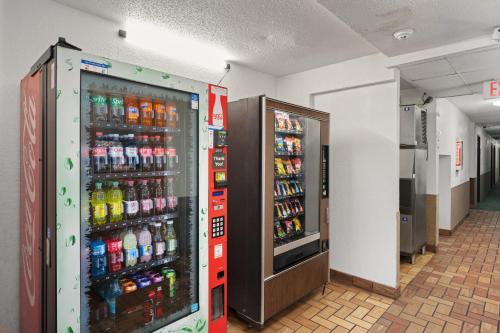 two soda machines in a hallway with soda bottles at StayInn Grand Forks in Grand Forks