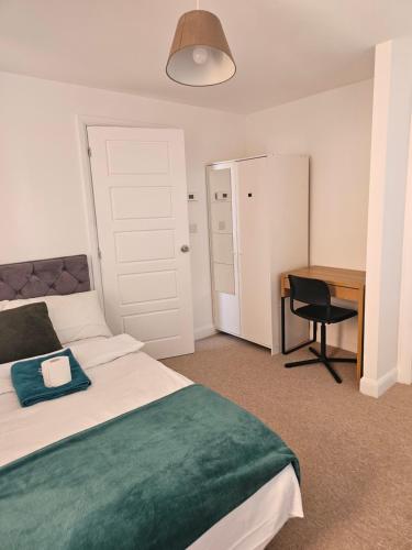 a bedroom with a bed and a desk and a table at Cosy Ensuite Doubleroom with Private Toilet and Bathroom in central Dartford in Dartford