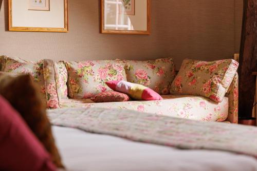 a couch with pillows on it in a room at Château de Castel Novel Boutique Hôtel in Varetz