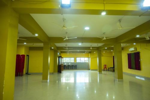 an empty room with yellow walls and yellow columns at Jalsa Lodge in Vishnupur