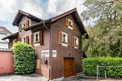 a brown brick house with windows and a door at Tailormade Hotel KRONE Sarnen in Sarnen