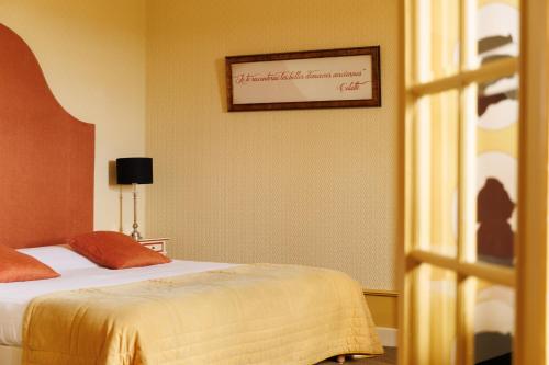 a bedroom with a bed and a picture on the wall at Château de Castel Novel Boutique Hôtel in Varetz