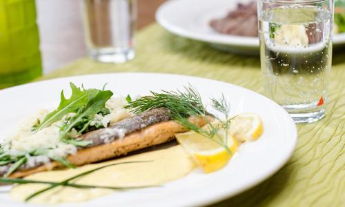 a white plate of food on a table at Hotel Schweinsberg in Lennestadt
