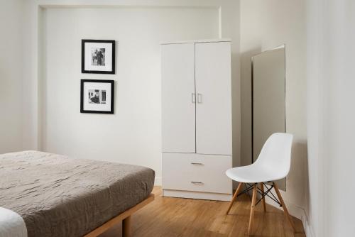 sypialnia z łóżkiem i białym krzesłem w obiekcie Superior Suite by Acropolis Cozy Suites w Atenach